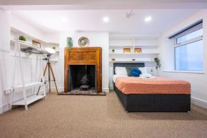 a bedroom with a bed and a fire place at Palmyra Square by Tŷ SA in Newport