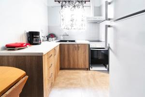 a kitchen with wooden cabinets and a refrigerator at Topfloor central apt with urban views,3' to metro in Athens