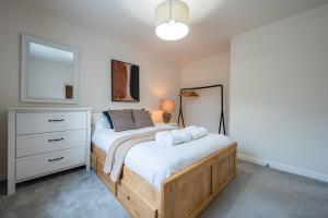 a bedroom with a bed and a dresser at Close to Warwick University - Clover Way by Tŷ SA in Canley