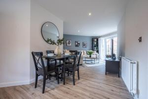a dining room with a table and chairs and a mirror at Close to Warwick University - Clover Way by Tŷ SA in Canley