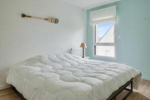 a large white bed in a room with a window at Maison pour 8 sur la Riviera Bretonne in La Forêt-Fouesnant