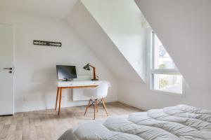 a bedroom with a bed and a desk with a computer at Maison pour 8 sur la Riviera Bretonne in La Forêt-Fouesnant