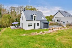 a white house with a large yard with grass at Maison pour 8 sur la Riviera Bretonne in La Forêt-Fouesnant