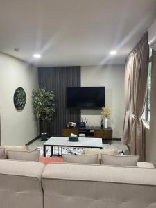 a living room with a couch and a tv at 1st inn hotel subang in Subang Jaya