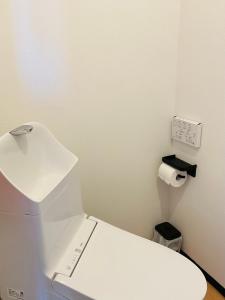 a white bathroom with a toilet and a roll of toilet paper at Warm House6 in Sapporo