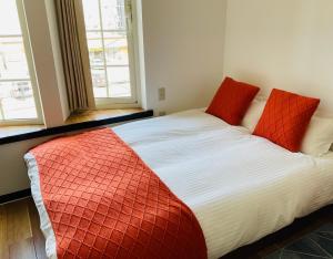 a bed with two red pillows in a room at Warm House6 in Sapporo