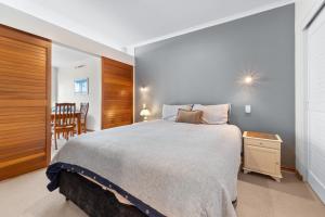 a bedroom with a large bed and a table at Metro Retreat - Auckland Central Apartment in Auckland