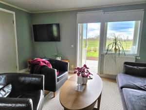 a living room with couches and a table and a tv at Gästhuset Sätuna in Sätuna