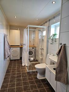 uma casa de banho com um lavatório e uma máquina de lavar roupa em Gästhuset Sätuna em Sätuna