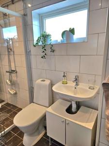 La salle de bains est pourvue de toilettes, d'un lavabo et d'une fenêtre. dans l'établissement Gästhuset Sätuna, à Sätuna