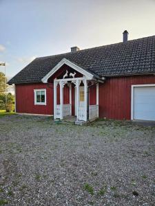 uma casa vermelha com uma porta branca e uma garagem em Gästhuset Sätuna em Sätuna
