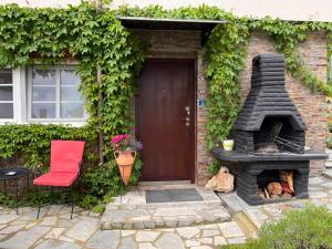 ein Backsteinhaus mit einem Kamin, einem Stuhl und einer Tür in der Unterkunft Mirka in Sremski Karlovci