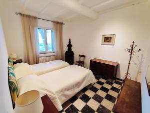 - une chambre avec 2 lits et un sol en damier dans l'établissement Borgo La Torre alle Tolfe, à Sienne