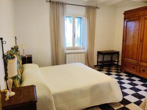 una camera con un letto bianco e una finestra di Borgo La Torre alle Tolfe a Siena