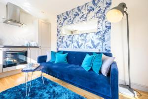 um sofá azul numa sala de estar com um tapete azul em Central Location - Riverside Gardens #3 by Tŷ SA em Cardiff