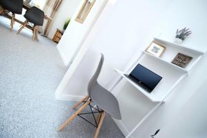 a desk with a laptop and a chair in a room at Parkview by Tŷ SA - spacious 3 bed in Newport in Newport