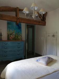 a bedroom with a canopy bed with a dresser and a bed sidx sidx sidx at Mazet A l Ombre des Z ' oliviers in Port-Sainte-Foy-et-Ponchapt