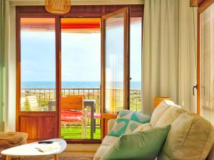 ein Wohnzimmer mit einem Sofa und Meerblick in der Unterkunft Apartamento Corrubedo Vistas Mar y Playa in Corrubedo