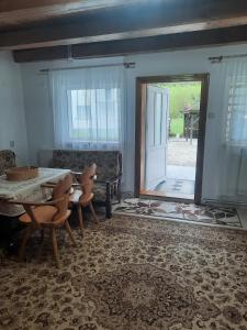 - un salon avec une table, des chaises et une porte dans l'établissement Cabanuta Dan & Alex, à Cârţişoara
