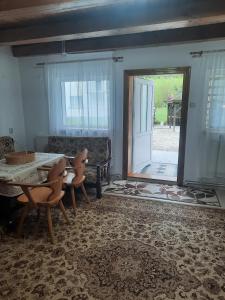 a living room with a table and chairs and a door at Cabanuta Dan & Alex in Cârțișoara +14 photos