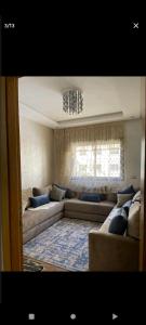 uma sala de estar com sofás e um lustre em اقامة ياسمين em Cité de Bournazel