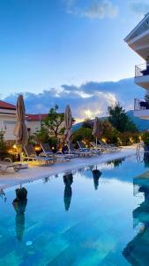 a swimming pool with lounge chairs and umbrellas at Payava Hotel by True Blue in Kalkan