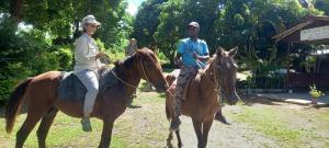 deux personnes à cheval dans un champ dans l'établissement Outback Retreat/Hotel, Ba Fiji, à Tonge