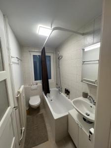 uma casa de banho com uma banheira, um WC e um lavatório. em Jungstay Apartments- near Basel em Basileia