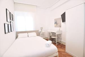 - une chambre blanche avec un lit et un bureau dans l'établissement Notel Club - Precioso apartamento Santander, à Santander