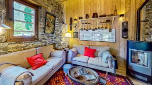 - un salon avec deux canapés et une télévision dans l'établissement Ca' Scocc, antica casa di montagna in Valsesia, à Mollia