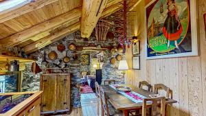 d'une salle à manger avec une table et un mur en pierre. dans l'établissement Ca' Scocc, antica casa di montagna in Valsesia, à Mollia