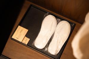 un par de zapatos blancos en una caja sobre una mesa en فندق الما ALMA Hotel, en Riad