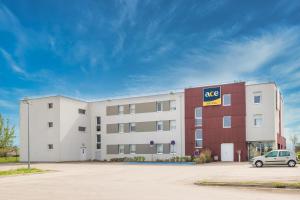 a large apartment building with a car parked in front at Ace Hotel Troyes in Saint-André-les-Vergers