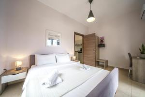 - une chambre avec un grand lit blanc dans l'établissement Dimitra & Deslina Luxury Αpartments, à Georgioúpoli