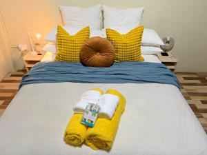 un letto con cuscini e asciugamani gialli e bianchi di “Marley’s Home“ a Lautoka