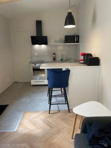 a kitchen with a counter and a blue chair at Studio in Vitry-sur-Seine