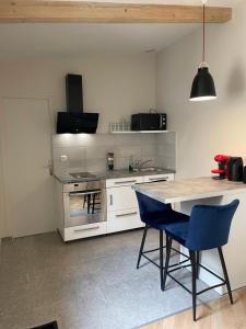 a kitchen with a table and blue chairs in it at Studio in Vitry-sur-Seine