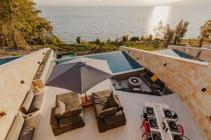 an overhead view of a pool with chairs and an umbrella at Villa Scorpio in Paleros