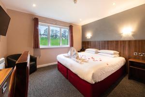 um quarto de hotel com uma cama e uma janela em Springfield Hotel & Health Club em Halkyn