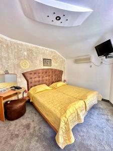 a bedroom with a large bed with a yellow bedspread at Hotel The Golden fish in Sozopol