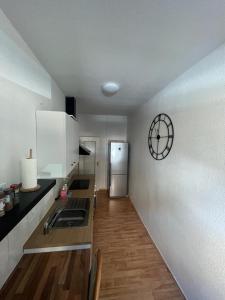 eine Küche mit einem Kühlschrank und einer Uhr an der Wand in der Unterkunft Elias 2 in Erfurt