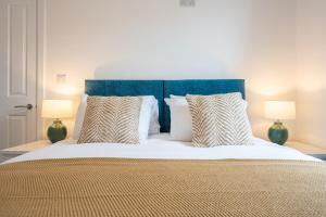 a bedroom with a large bed with two lamps at Durham View by Tŷ SA in Newport