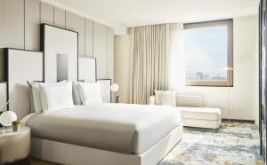 a bedroom with a large white bed and a couch at Grand Hyatt Barcelona in Barcelona