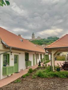 una fila de casas verdes y blancas en Pannonhalma Várlak Vendégház, en Pannonhalma