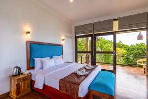 a bedroom with a large bed and a balcony at Park Paradise Rumassala in Galle