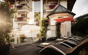 a row of lounge chairs on a balcony of a building at eva,VILLAGE in Saalbach-Hinterglemm