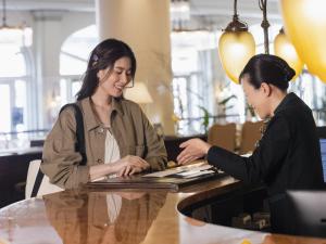 two women sitting at a table with a laptop at Hotel Europe Huis Ten Bosch in Sasebo
