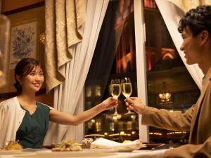 a man and woman holding glasses of wine at Hotel Europe Huis Ten Bosch in Sasebo