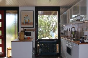 una cocina con una puerta que da a una cocina con fogones en Haus Rosebud, en Weilheim