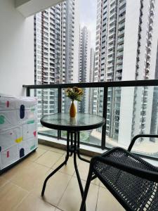 a table and a chair on a balcony with buildings at R&F PRINCESS COVE at ANJU in Johor Bahru